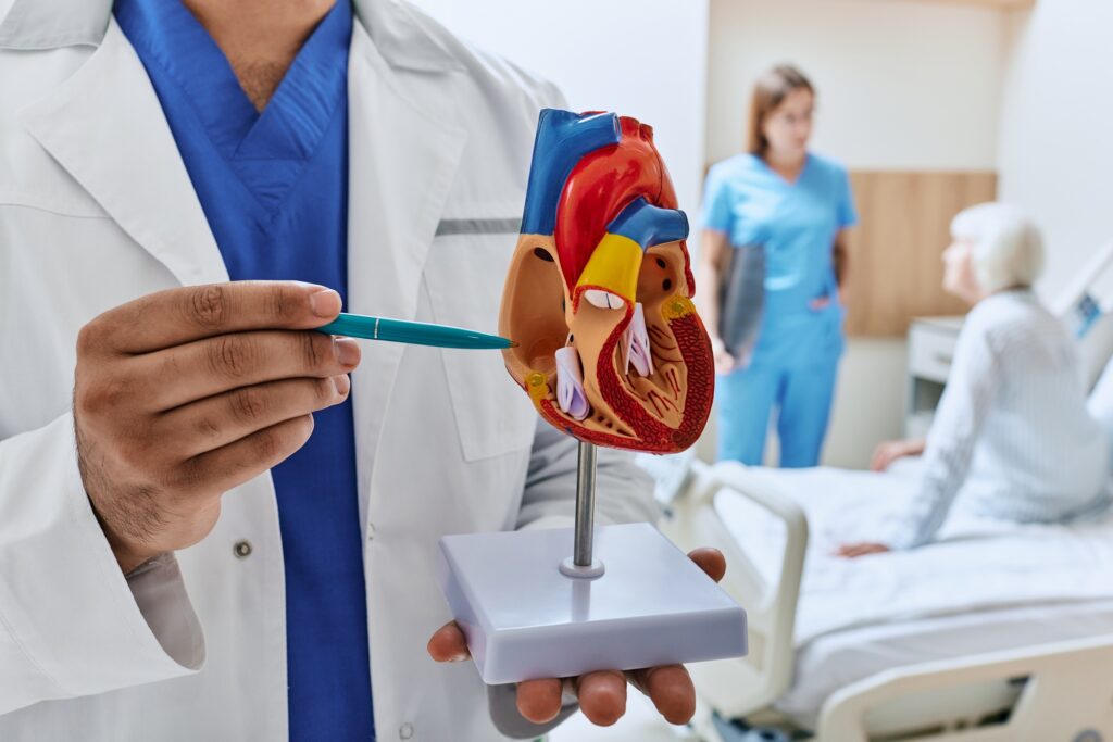 Elderly patient in cardiology ward of hospital with doctors analyzing her health and showing